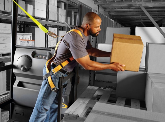 Forklift operator packs a pallet on an elevated rental forklift from Crown