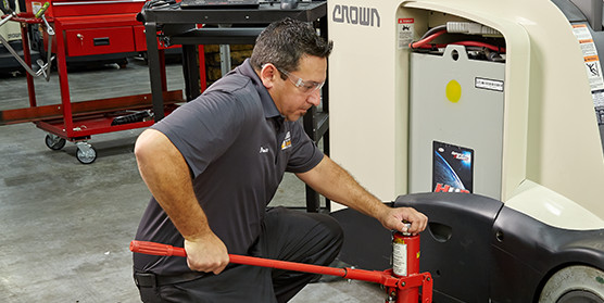 Crown service technician performs maintenance on forklift